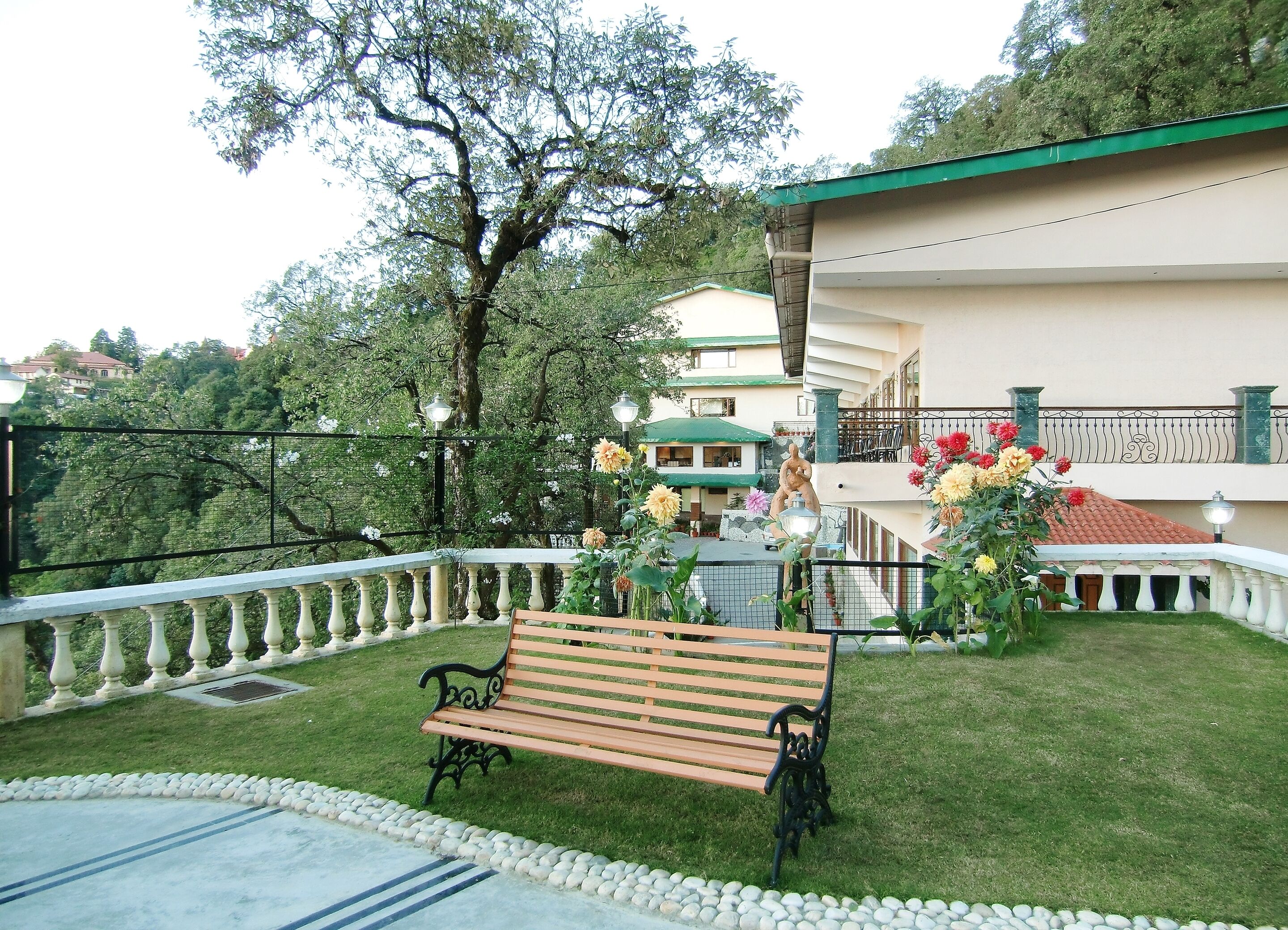 Un banc dans un jardin, avec vue sur un bâtiment et des arbres.