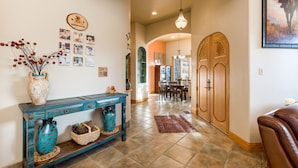 A hallway with a wooden console table, a vase, and a rug.
