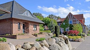 A row of traditional brick houses with steep roofs, stone steps, and a stone wall in the foreground. - Ferienwohnung mit Terrasse am Hafen in Seedorf 08 - 08 Ferienwohnung mit Terrasse am Hafen in (Sellin)