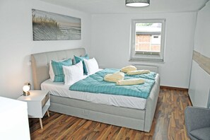 Une chambre bien rangée, avec un lit, une table de chevet et une fenêtre.