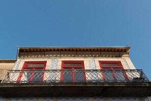 Stunning building with a unique architectural style, featuring a balcony with a wrought iron railing and decorative columns.