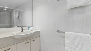 Ein modernes Badezimmer mit Waschbecken, Spiegel und gefliesten Wänden.