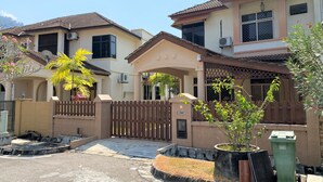 A residential area with houses featuring tiled roofs and a gated entrance.