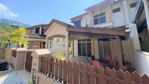 A residential building with a covered patio area, a gated entrance, and a small garden.