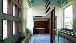 A modern hallway with a ceiling mural, large windows, and a reception desk. - Lato Annex Boutique Rooms (Heraklion)