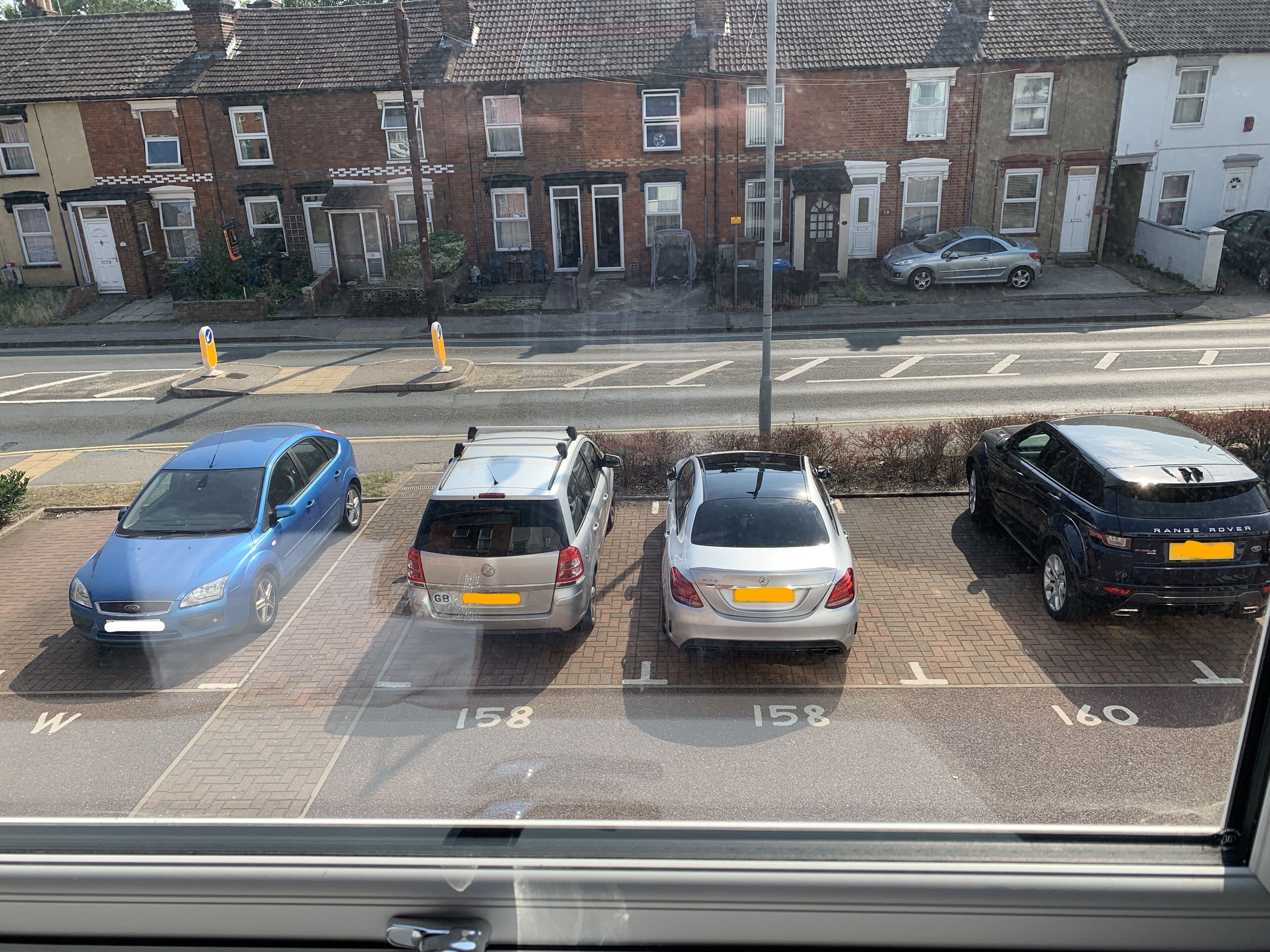 Un parcheggio con quattro auto parcheggiate negli stalli assegnati.