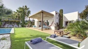 A modern outdoor patio with a pool, lounge chairs, and a hammock. - Modern villa with private pool and garden (Mar de Cristal)