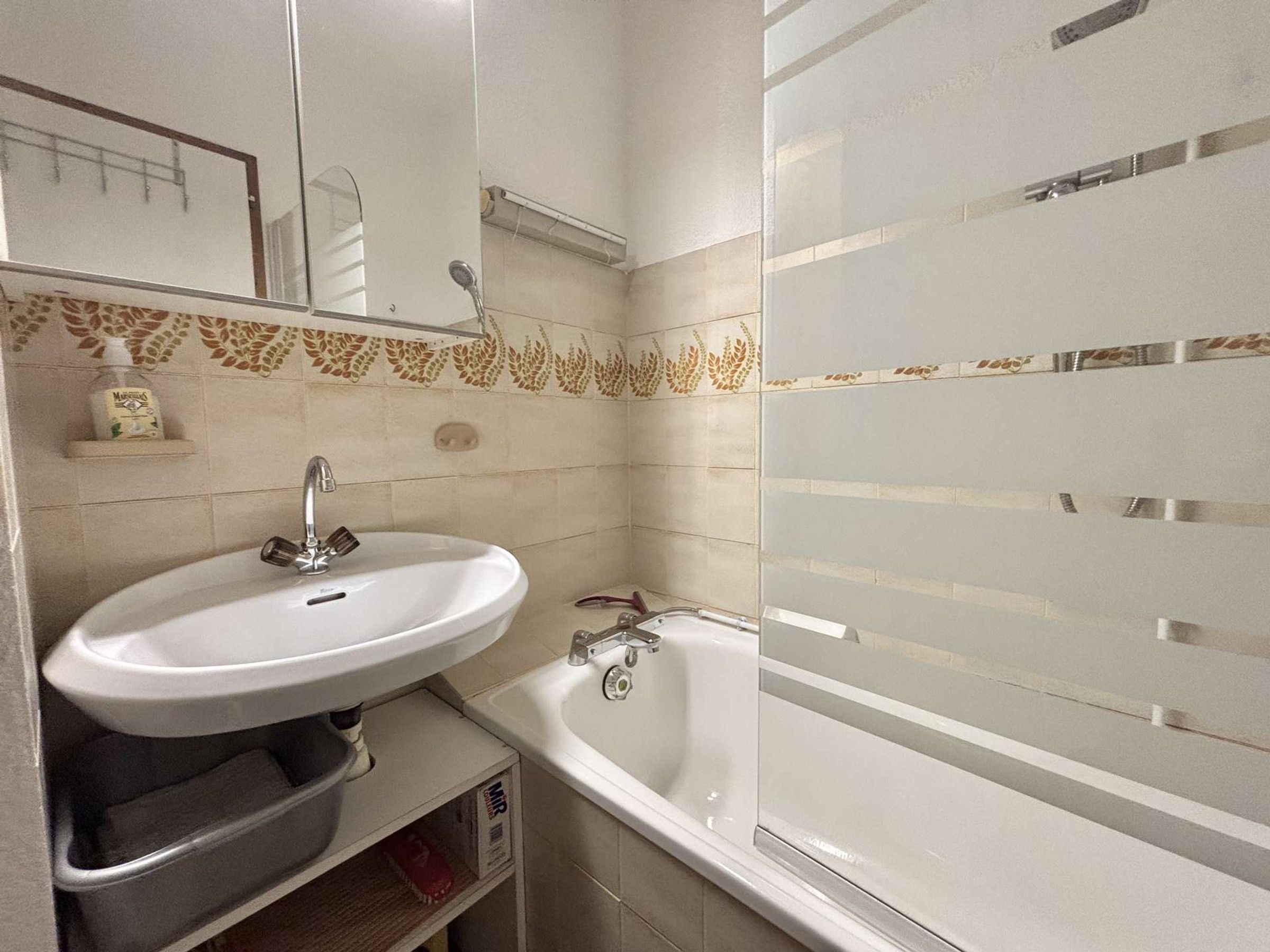 Ein Badezimmer mit Waschbecken, Spiegel, Dusche und Toilette.