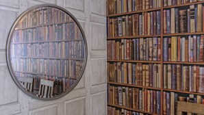 Un miroir rond reflète une bibliothèque remplie de livres.