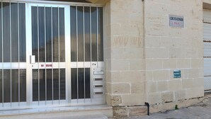 Une entrée d’immeuble avec un portail en métal, une enseigne indiquant « Grosvenor » et un panneau indiquant « PROPRIÉTÉ PRIVÉE – DÉGAGEMENT OBLIGATOIRE ».