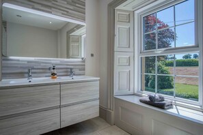 Een aparte badkuip en douche, een diep bad, een hydromassagedouche