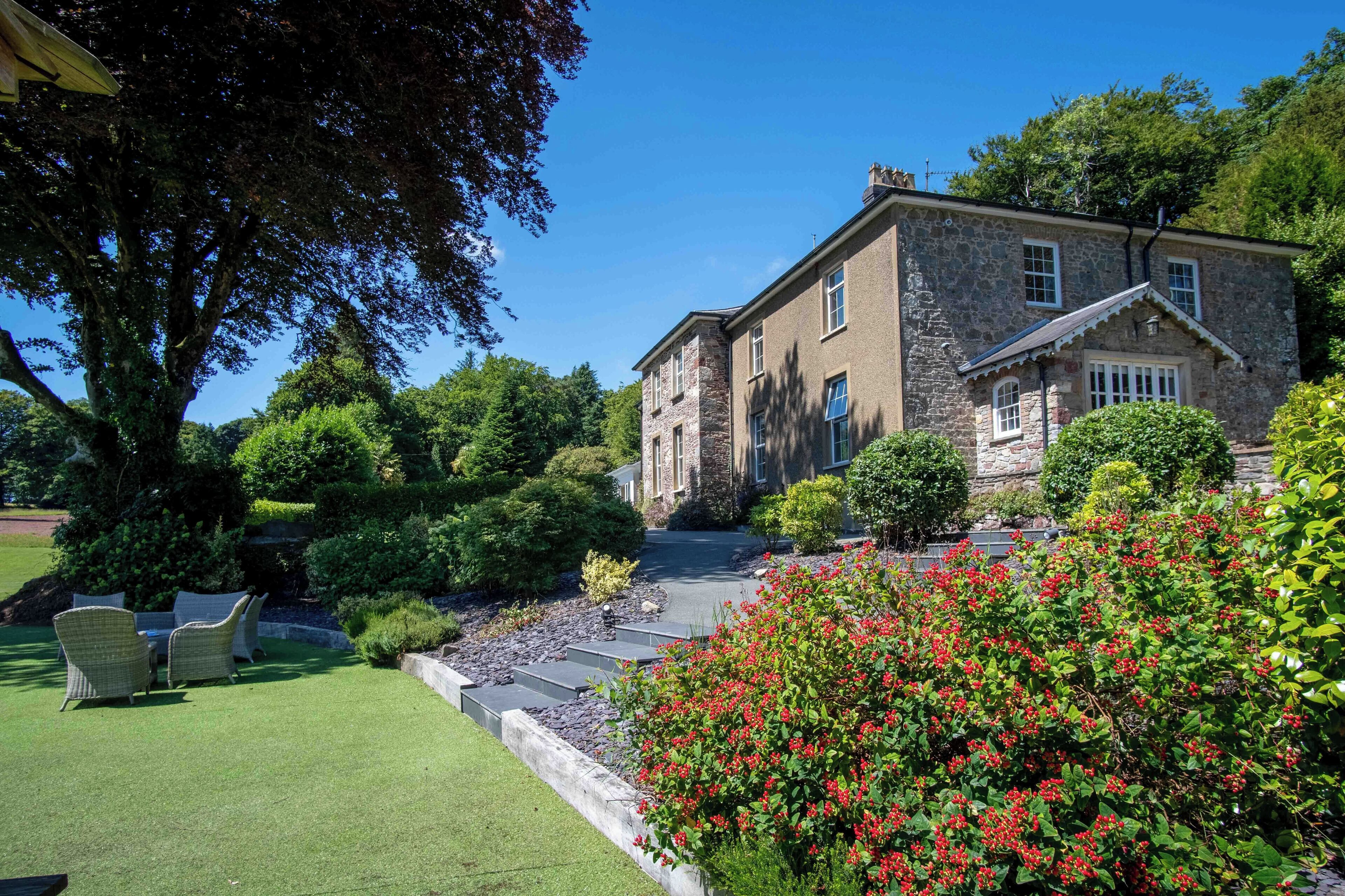 A stone building with a well-maintained lawn and outdoor seating area.