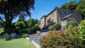 A stone building with a well-maintained lawn and outdoor seating area.