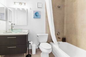 Une salle de bain moderne avec un lavabo en verre, des toilettes et une baignoire.
