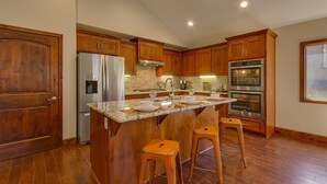 A kitchen with wooden cabinets, stainless steel appliances, and a granite countertop. - AC, Custom Bunks, Bubble Hockey, Sauna, Walk to Heavenly/ Lake, Grill – Tahoe Woods Paradise (South Lake Tahoe)