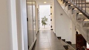 Ein Flur mit Treppe und einer kleinen Pflanze.