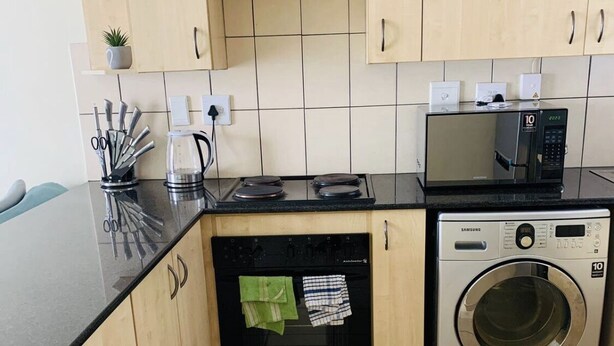 A compact kitchen with a dishwasher, microwave, and washing machine. - Innoprop @Midrand (Midrand)