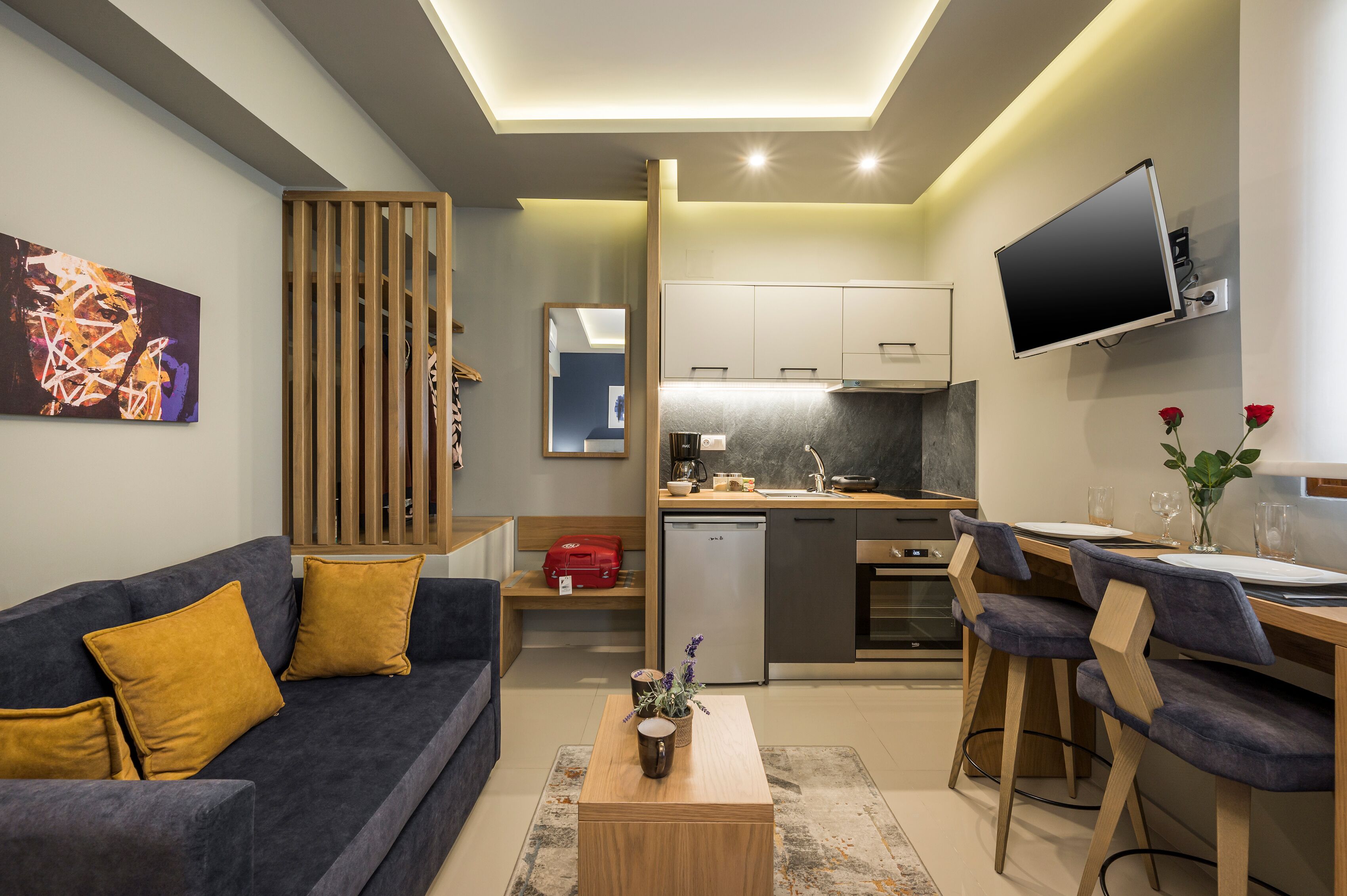 A modern living room with a sofa, coffee table, and a TV mounted on the wall.