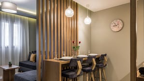 A modern dining area with a wooden table, dark chairs, and hanging pendant lights. -  MIRMA CITY studio & apartment (Chania)