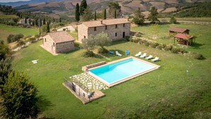 A stone house with a swimming pool surrounded by a grassy lawn and a few trees. - PODERE OLIVETO Radicofani (SI) (Radicofani)