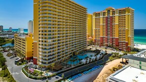 A high-rise hotel with multiple balconies, a swimming pool, and a beach view. - Calypso 2003W | 20th-Floor Gulf Views, Beach Service Included, Steps from Pier Park (Panama City Beach)