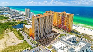 A high-rise hotel with multiple balconies, a beach view, and a parking area. - Calypso 2003W | 20th-Floor Gulf Views, Beach Service Included, Steps from Pier Park (Panama City Beach)