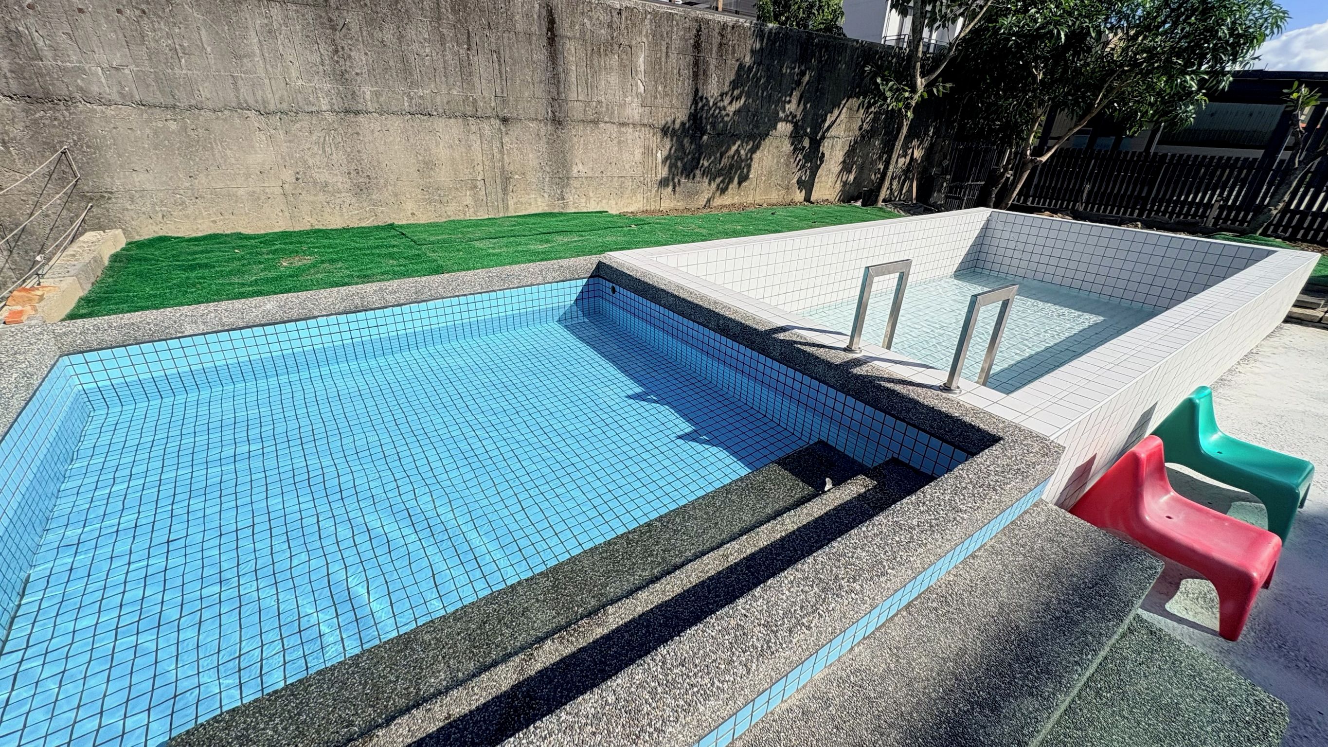 Una piscina con borde de azulejos y escalones para entrar.