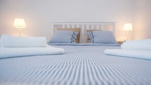 Een hotelkamer met een groot bed, twee kussens en twee bedlampjes.