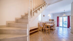 Una escalera que lleva a un comedor con una mesa y sillas.