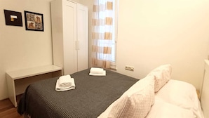 A hotel room with a bed, a wardrobe, a small table, and a window with curtains. - Vera - Cozy Solo Retreat: 1BR Apartment for Two, Parking Included (Baška)