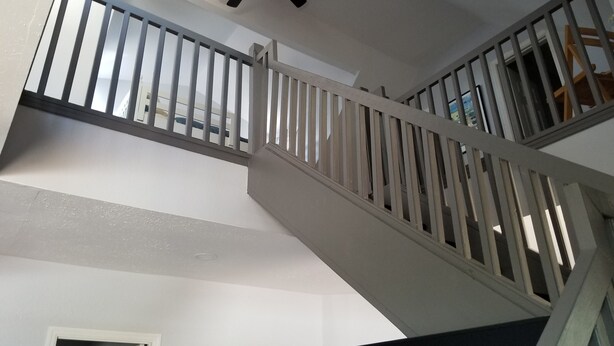 A staircase with white railings and a ceiling fan. - Amazing Renovated Historic Loft on Main Street (Saint Charles)