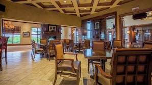 A spacious lobby with a fireplace, comfortable seating, and large windows offering views of the outdoors.