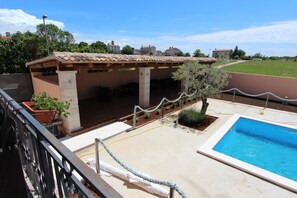 A covered outdoor area with a pool, a pergola, and potted plants. - Apartments Rubil (Bale)