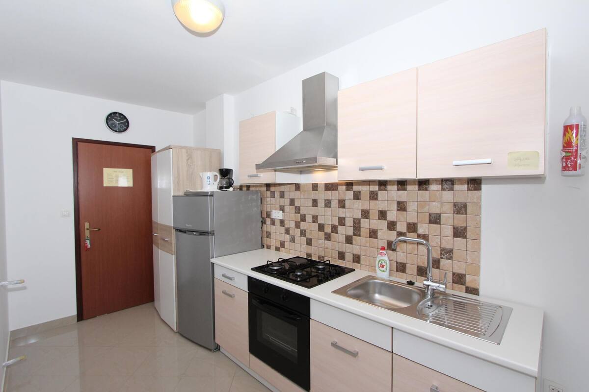 Una cocina moderna con estufa, fregadero y refrigerador.