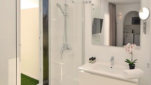 Ein modernes Badezimmer mit Duschkabine aus Glas, Waschbecken und Spiegel sowie einer Orchidee im Topf.