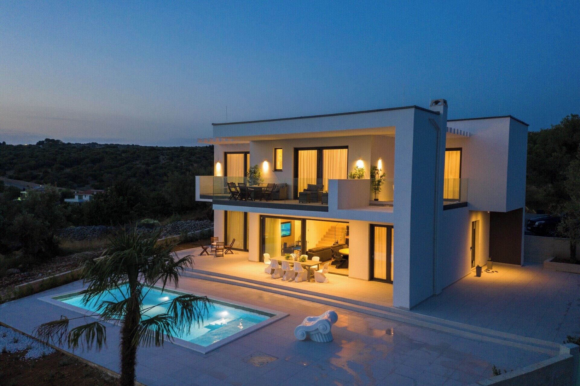 Uma casa moderna de dois andares com piscina, área de estar ao ar livre e varanda.