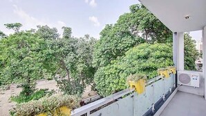 A balcony with a view of trees and a clear sky.