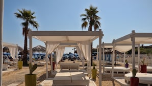 A beachside lounge area with white canopies, lounge chairs, and potted cacti. - Futura Club Spiagge Bianche (Syracuse)
