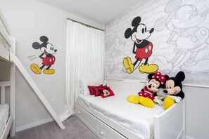 A child's bedroom with Mickey Mouse and Minnie Mouse wall decals, a white bed, and a small white dresser. - Solara Resort Retreat: Perfect for Large Families! (Kissimmee)