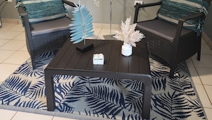 A room with two wicker chairs, a dark wooden coffee table, and a decorative plant. - Playa Escondida (Fajardo)