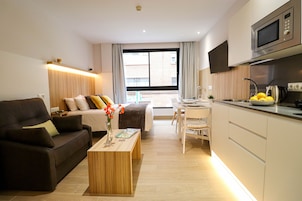 Ein modernes Wohnzimmer mit einer Couch, einem Couchtisch und einem Essbereich mit Tisch und Stühlen.