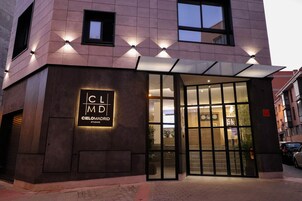 Ein modernes Gebäude mit Glastür, einem Schild mit der Aufschrift "Cielomadrid" und einer Ziegelwand.