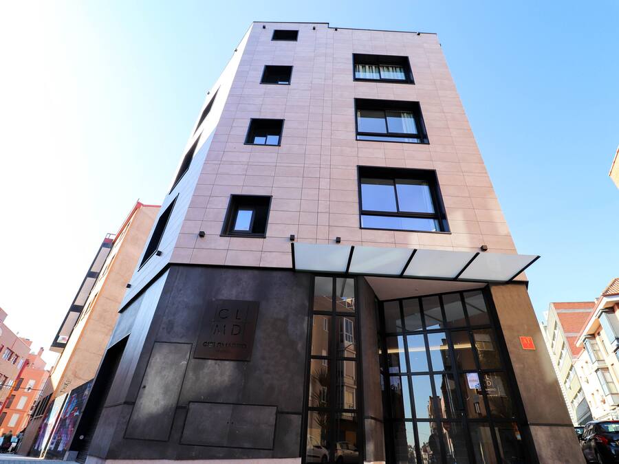 A modern building with a glass entrance and a sign reading "CLIMD Madrid".