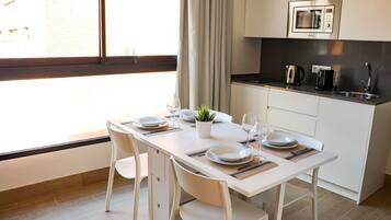 A modern kitchen with white cabinets, a microwave, and a sink.