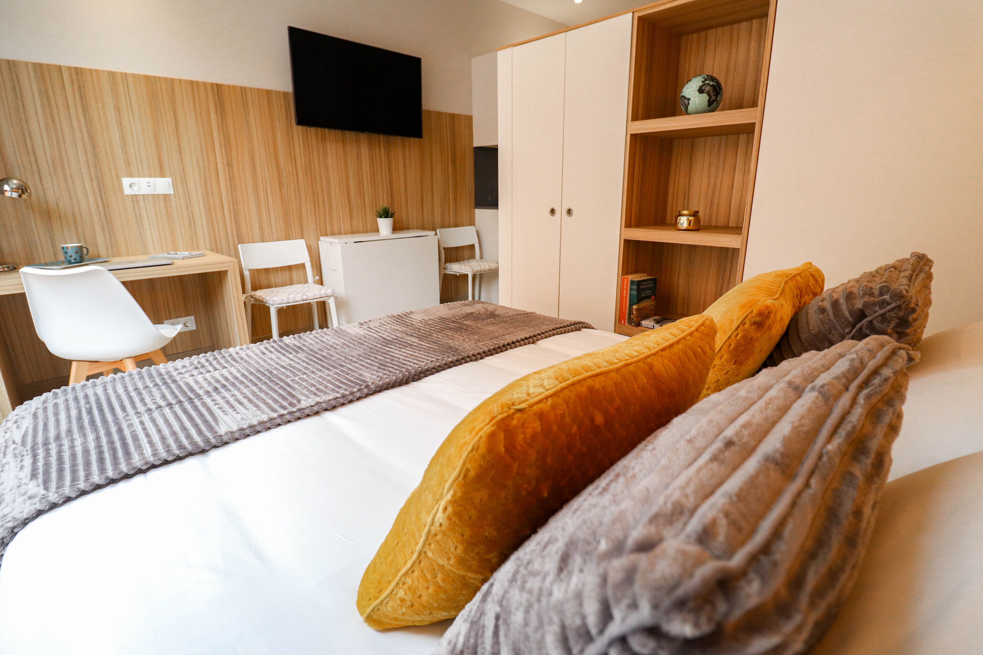 A modern bedroom with a bed, a desk, and a chair.
