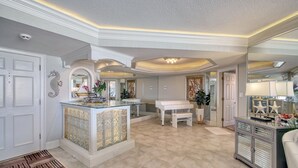 A spacious foyer with a piano, a glass coffee table, and a decorative mirror. - Wake up to beautiful ocean views!!! (MYRTLE BEACH)