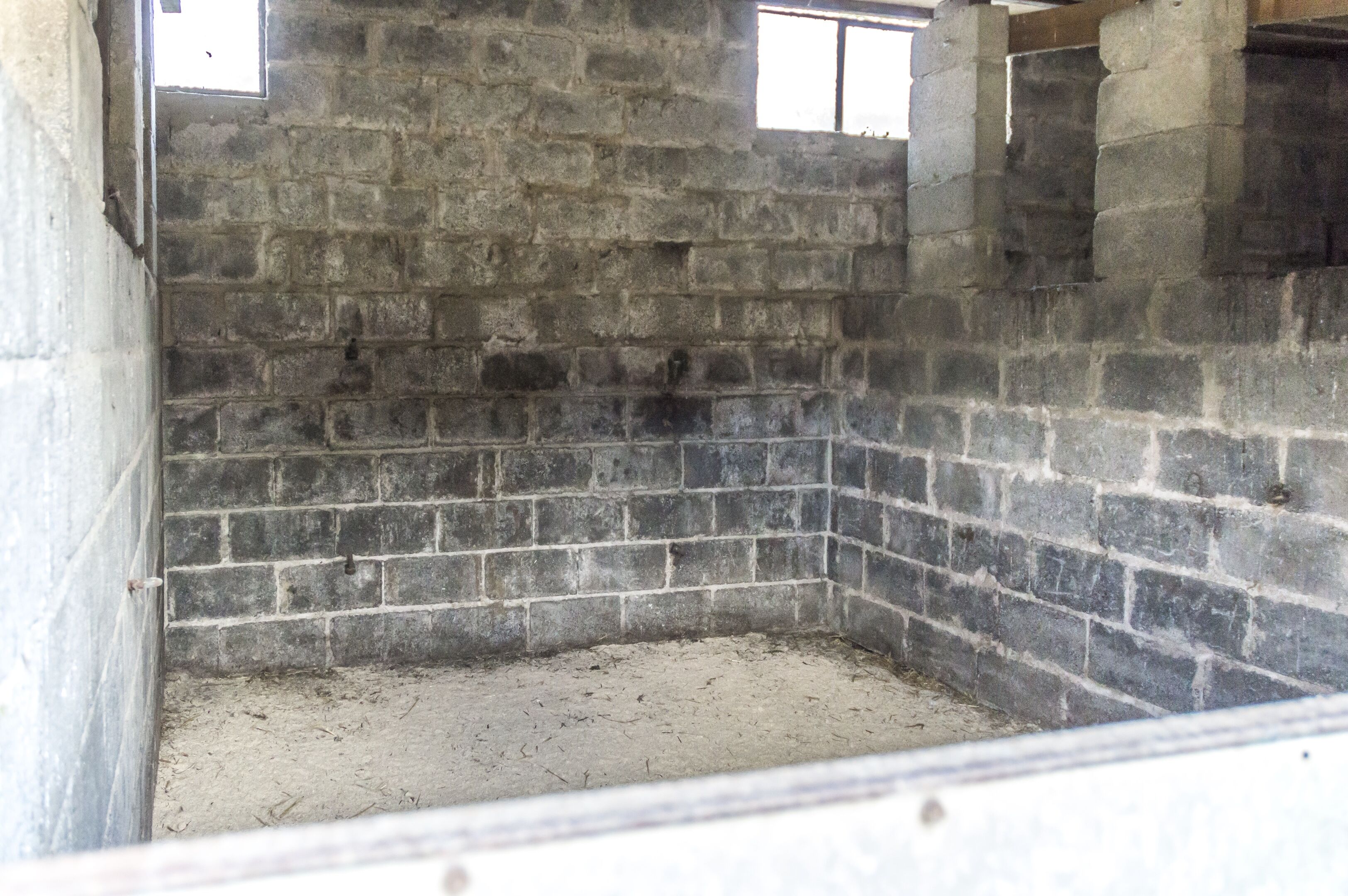 Una habitación con pared de ladrillo y una ventana.