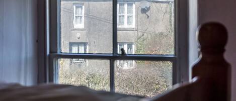 Una habitación con un ventanal grande, una cama y vistas a un edificio.