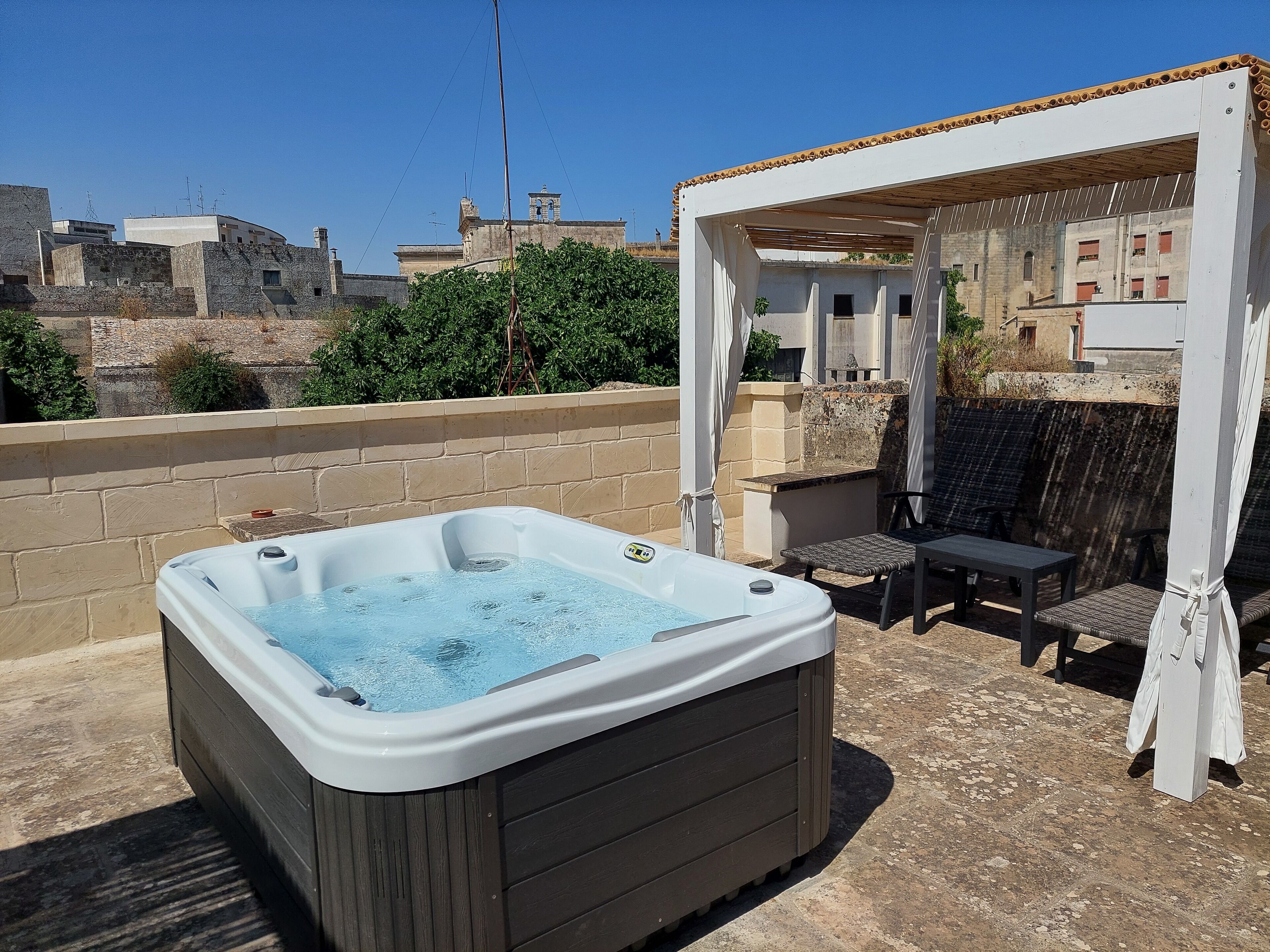 A hot tub on a patio with a pergola overhead.