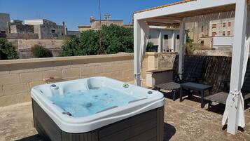 A hot tub on a patio with a pergola overhead.